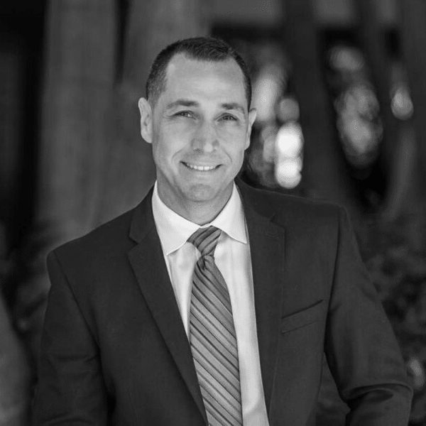 A black and white portrait of a man in a suit and tie.