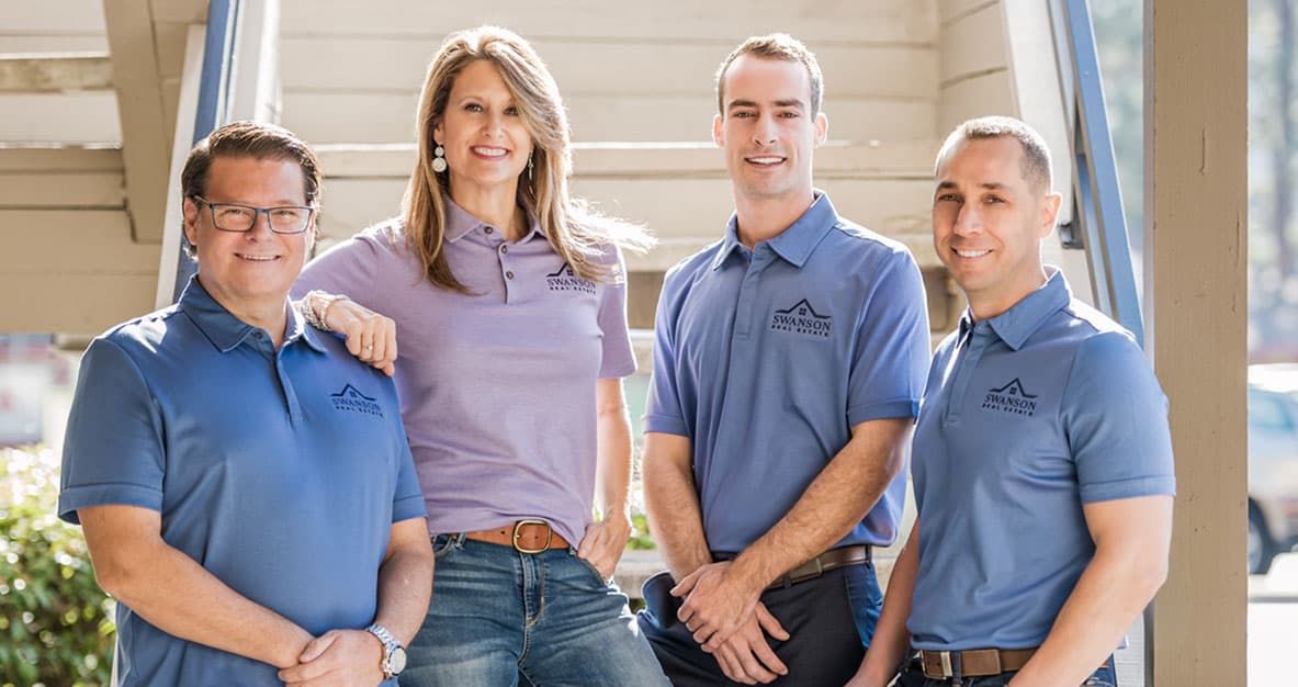 Four people posing in casual work attire.